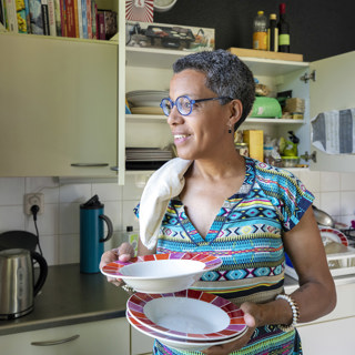 Bewoonster in haar woning borden aan het wegleggen